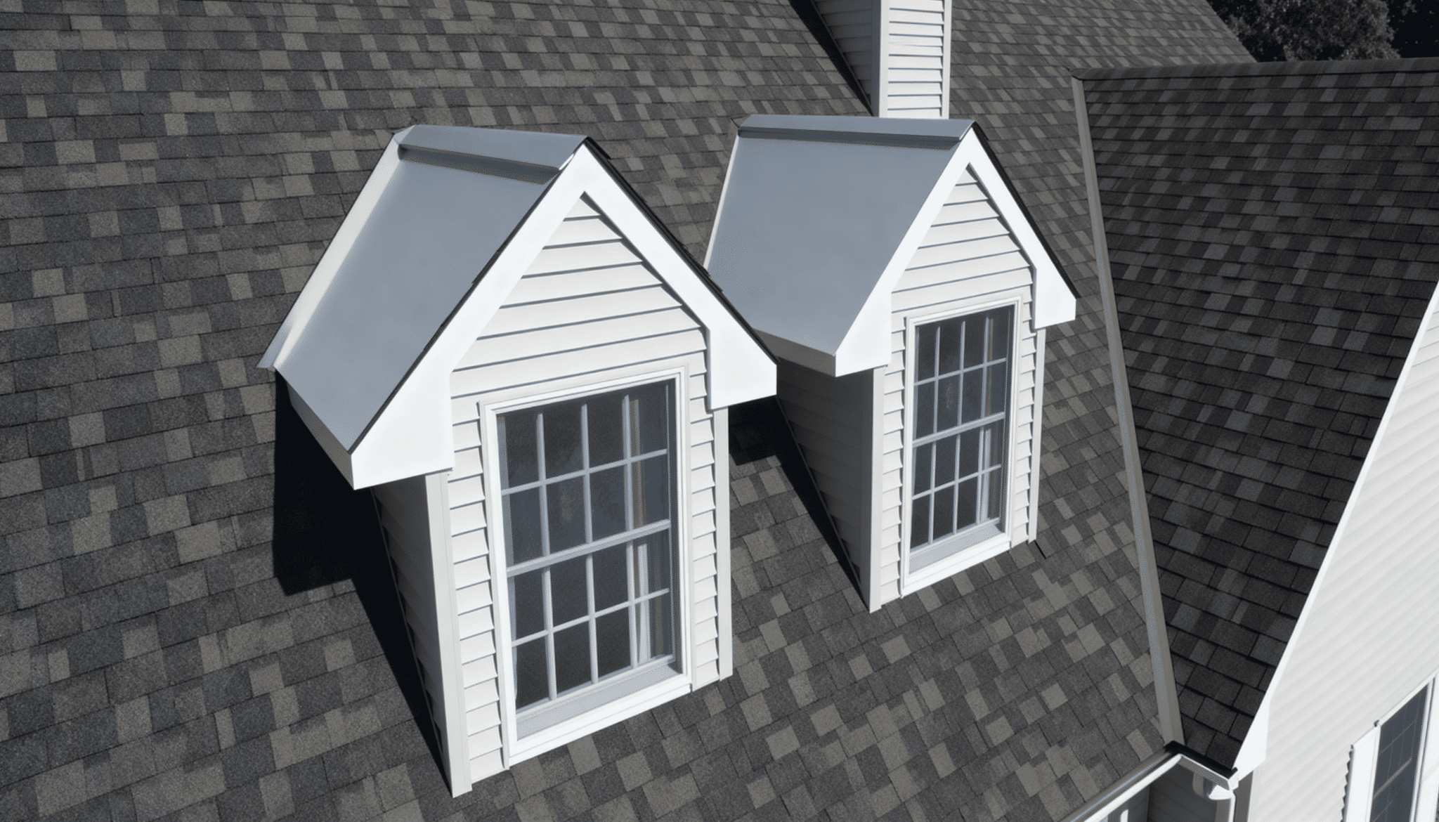 Two matching gable dormers with white siding on a gray shingled residential roof
