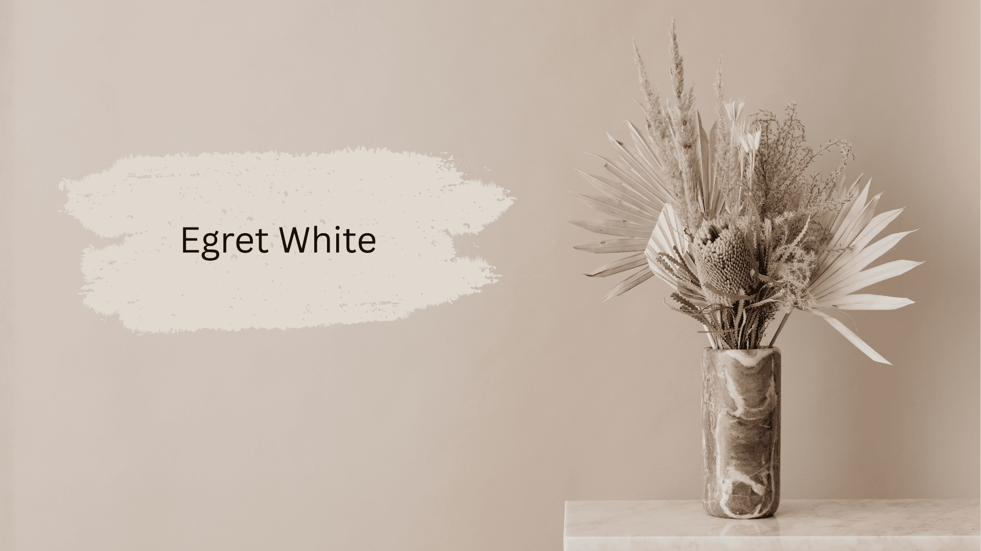 A paint swatch of Egret White is displayed next to a marble vase holding a dried floral arrangement against a muted beige wall