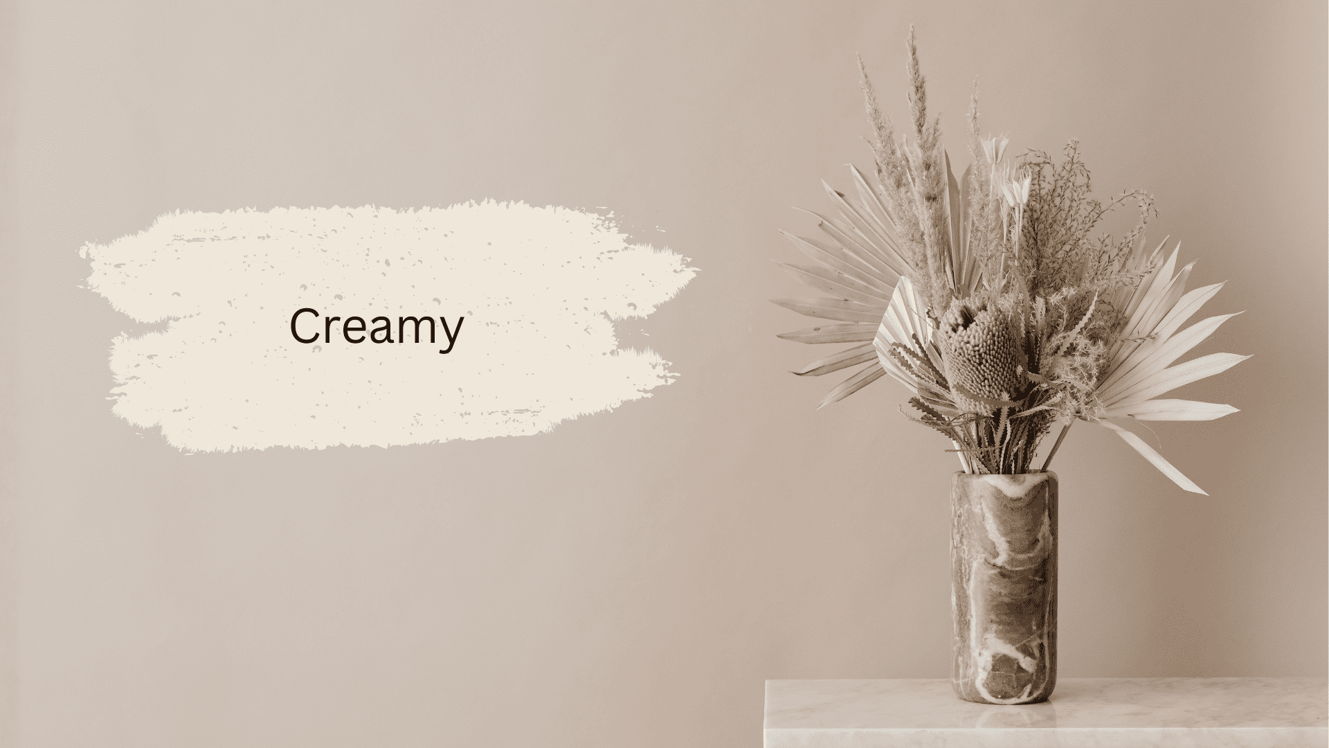 Creamy white paint swatch against a warm beige wall with a dried botanical arrangement in a marble vase (1)