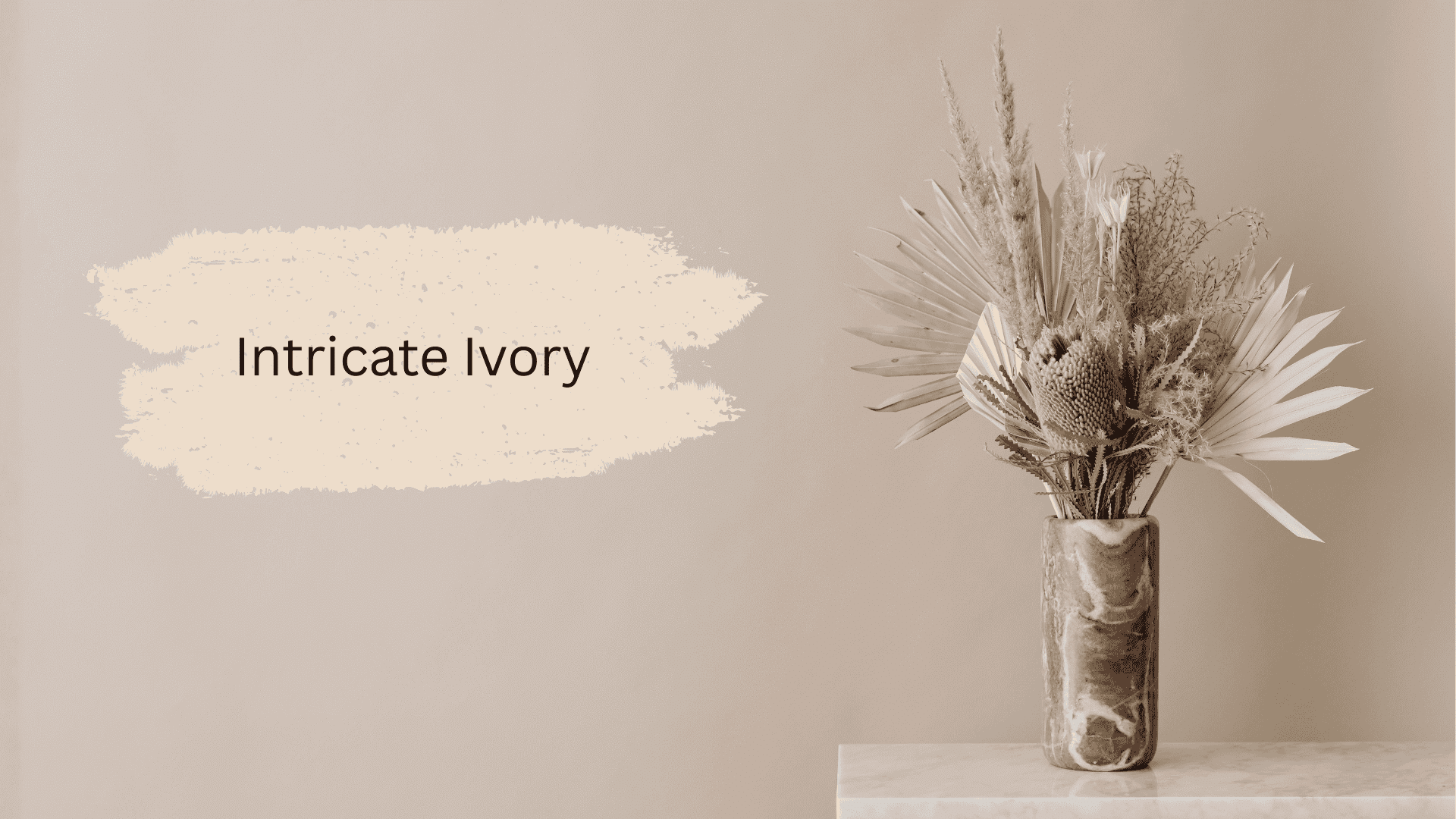 Neutral beige wall featuring a paint swatch labeled Intricate Ivory next to a vase of dried bohemian floral arrangement on a marble surface