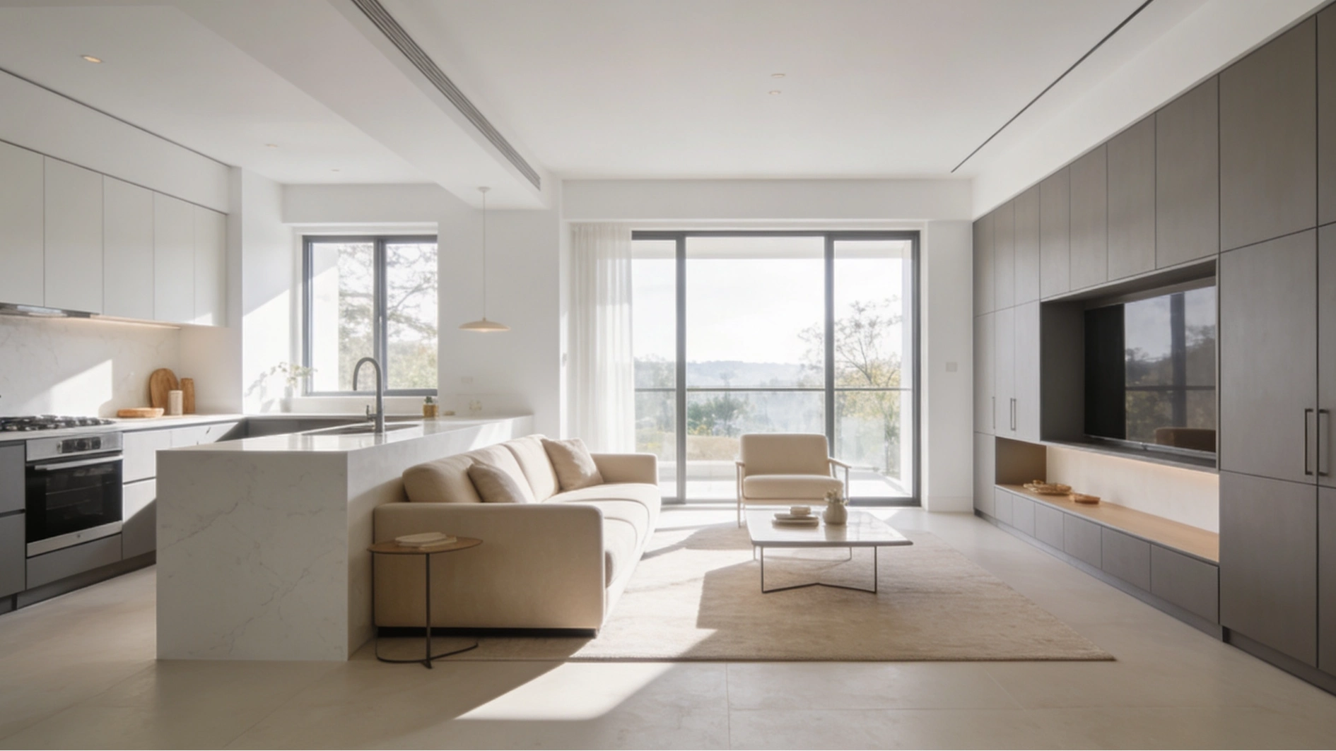 Modern open-plan living space combining a minimalist kitchen with a bright living area featuring large windows and dark integrated media cabinetry.